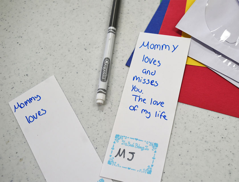 Handmade bookmarks, a marker, and construction paper.